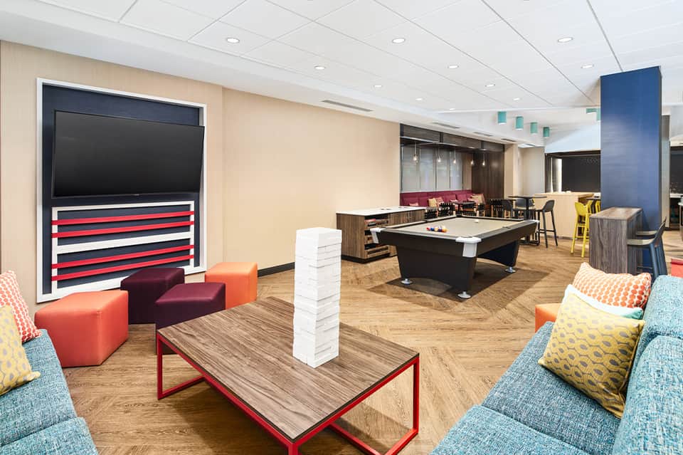 Recreation room with pool table, entertainment seating, and TV in contemporary hotel space