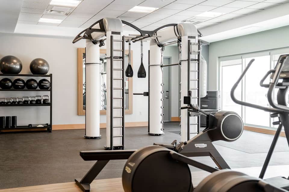 Modern fitness center with strength training equipment, free weights, and exercise machines