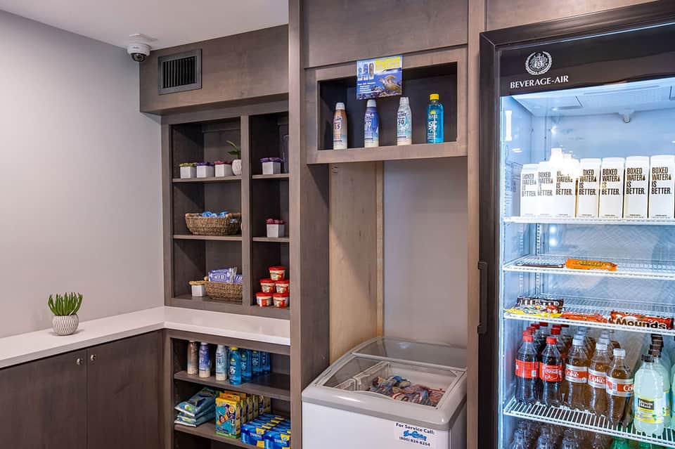 Convenience shop stocked with sunscreen, snacks, beverages, and boxed water in organized shelving