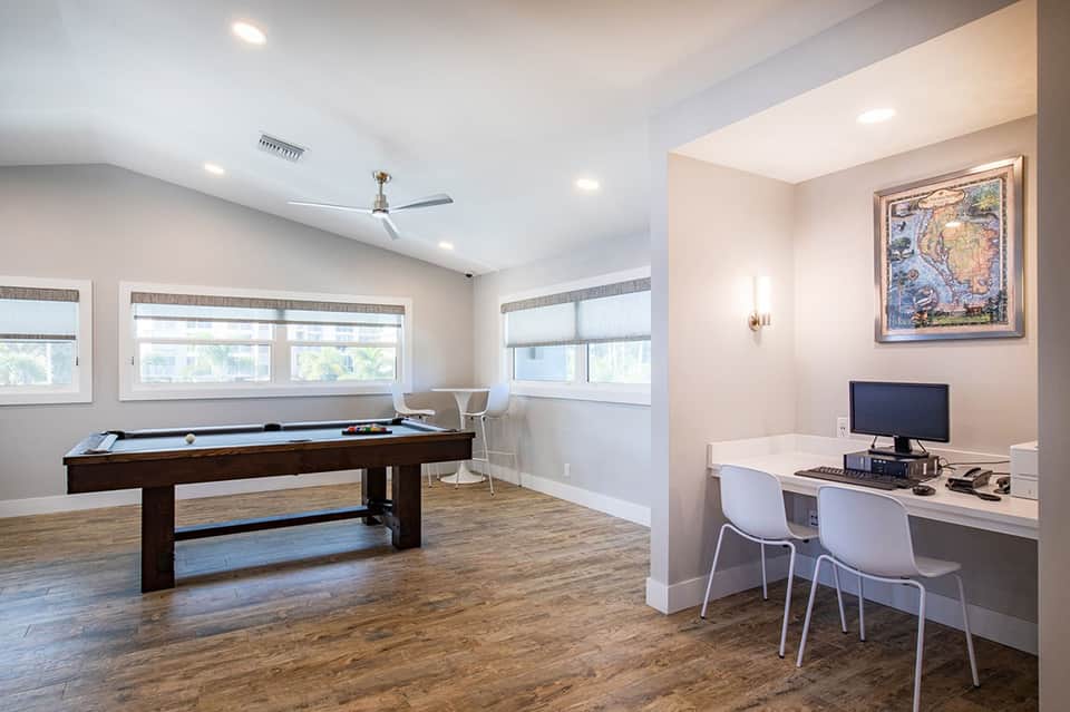 Game room with pool table, work desk, computer, ceiling fan and large windows with natural light
