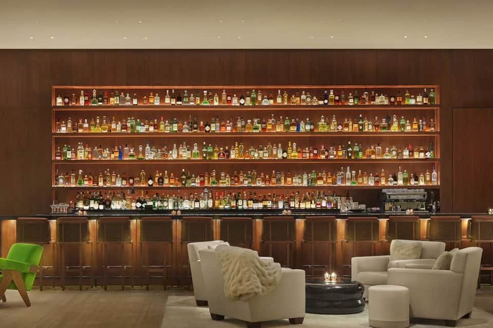 Upscale hotel bar with extensive liquor collection and lounge seating