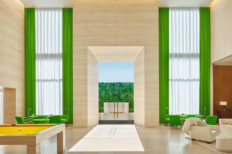 Modern wellness center with green curtains, wood walls, and courtyard fireplace view