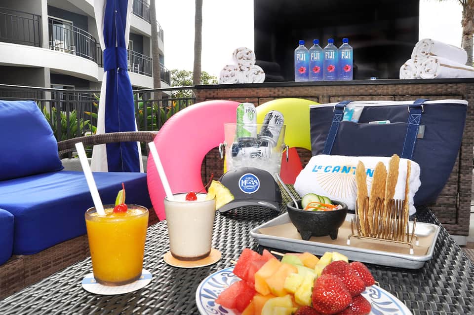 Beachfront cabana with colorful pillows, beverages, fresh fruit, and vibrant resort furnishings