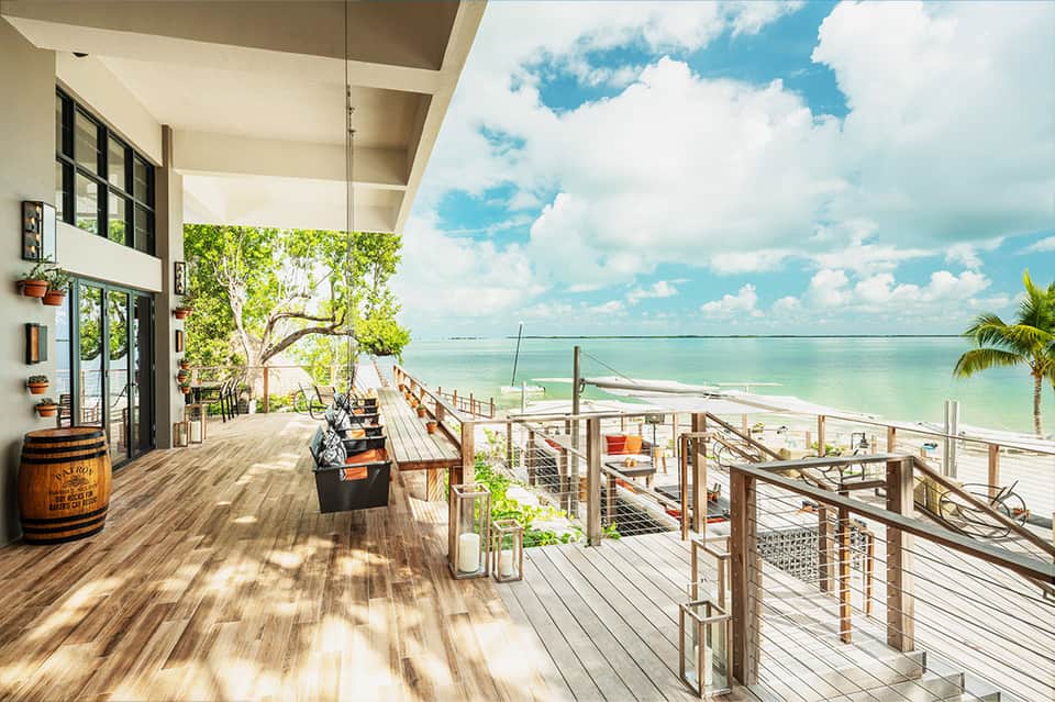 Beachfront deck with ocean view, modern white building, and wooden railings