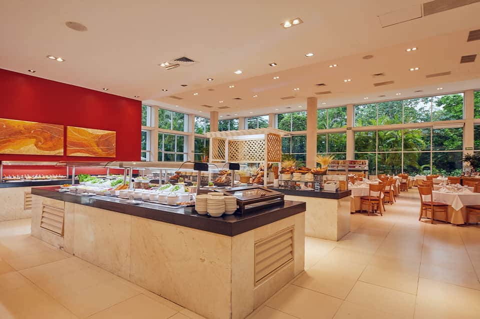 Spacious resort dining buffet with red accent walls, seafood displays, and floor-to-ceiling windows