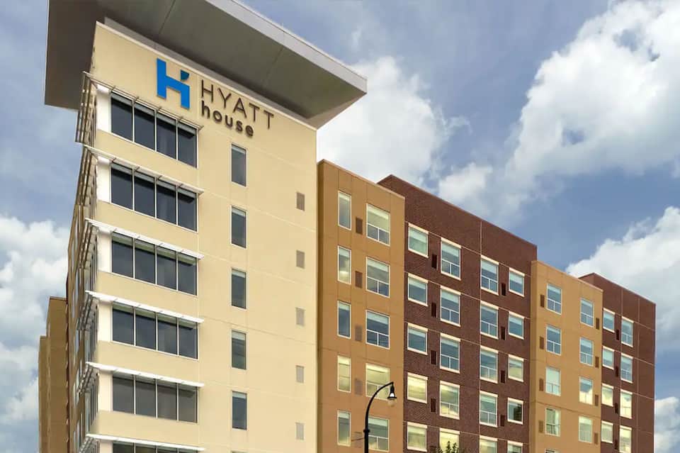 Hyatt House hotel exterior with yellow and brick facade against blue sky
