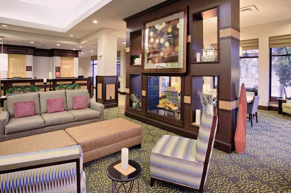 Hotel lobby with neutral seating, decorative wood wall panels, and elegant contemporary interior design