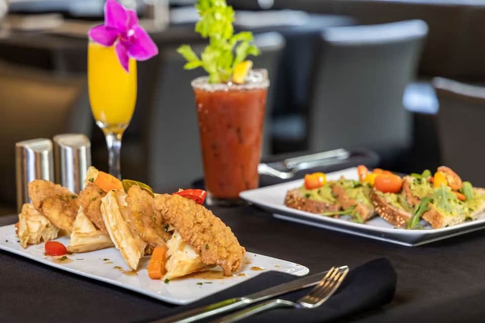 Gourmet appetizers and tropical cocktails on dining table indoors