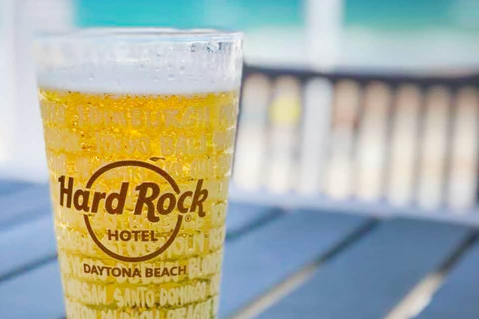 Hard Rock Hotel Daytona Beach branded beer glass with golden lager on waterfront deck