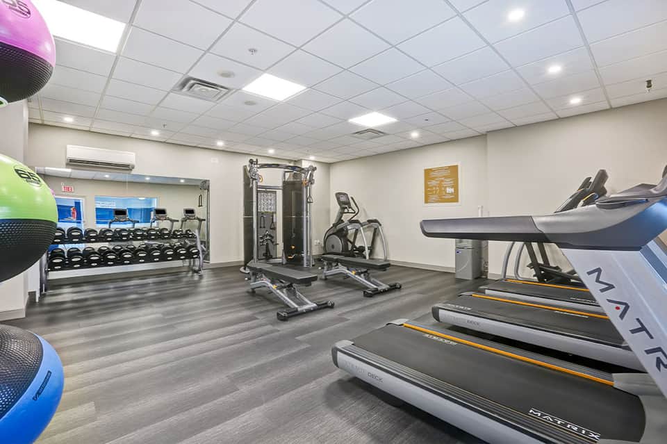 Fitness center with treadmills, dumbbells, exercise equipment, and modern workout facilities