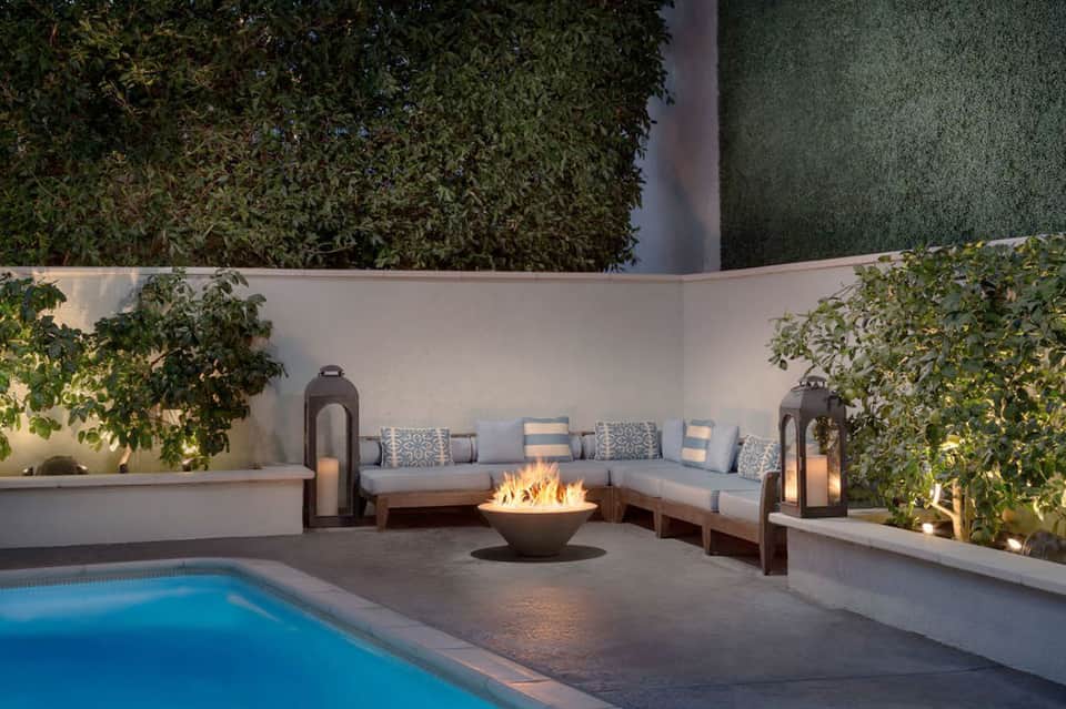 Modern courtyard patio with fire bowl, built-in seating, and swimming pool