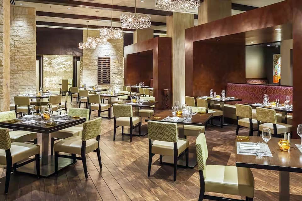 Fine dining restaurant with stone walls, elegant seating, and crystal chandeliers