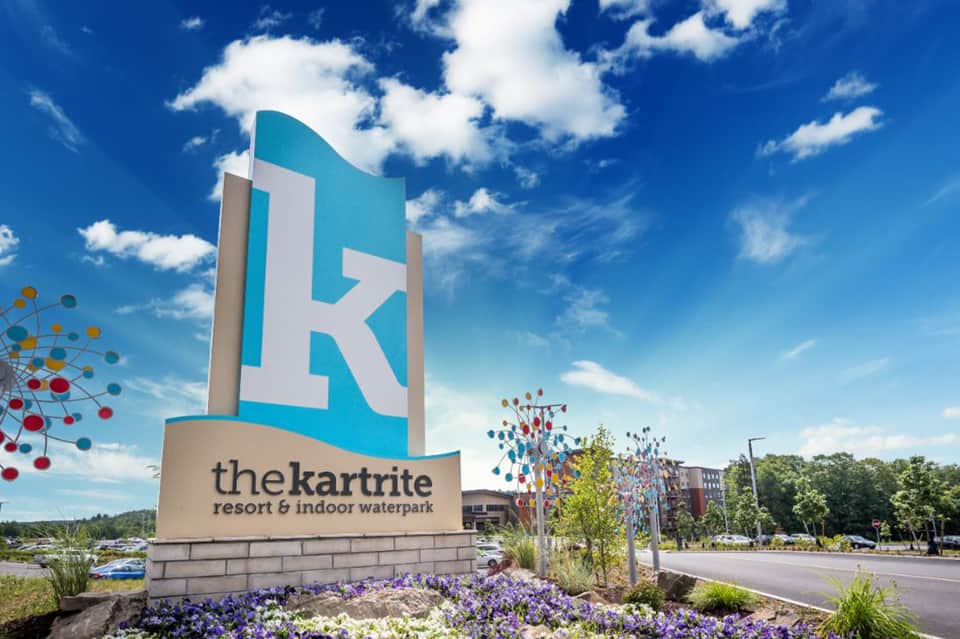 Kartrite Resort sign with turquoise K logo and colorful flowers under blue sky