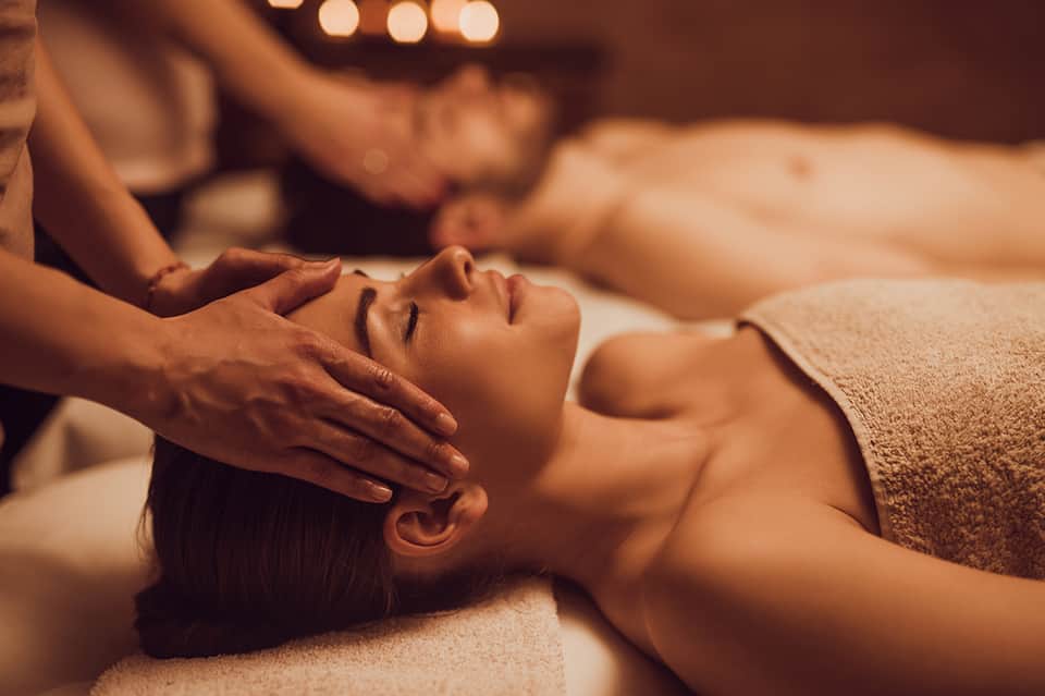 Woman receiving relaxing head and neck massage at spa with warm lighting