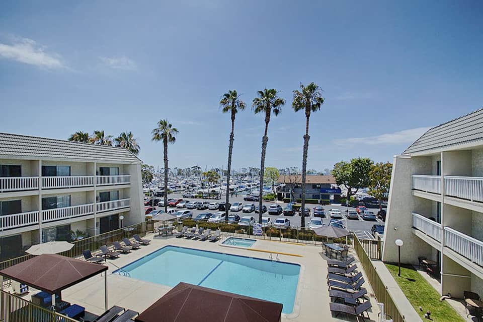 Resort courtyard with rectangular swimming pool, palm trees, and multi-story building wings