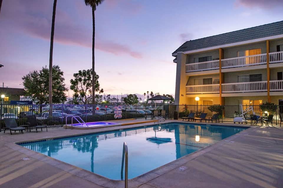 Resort pool at twilight with illuminated hotel building and palm trees