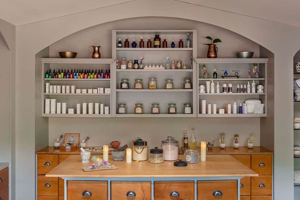 Wellness spa retail display with arched shelves holding colorful bottles, jars, and beauty products