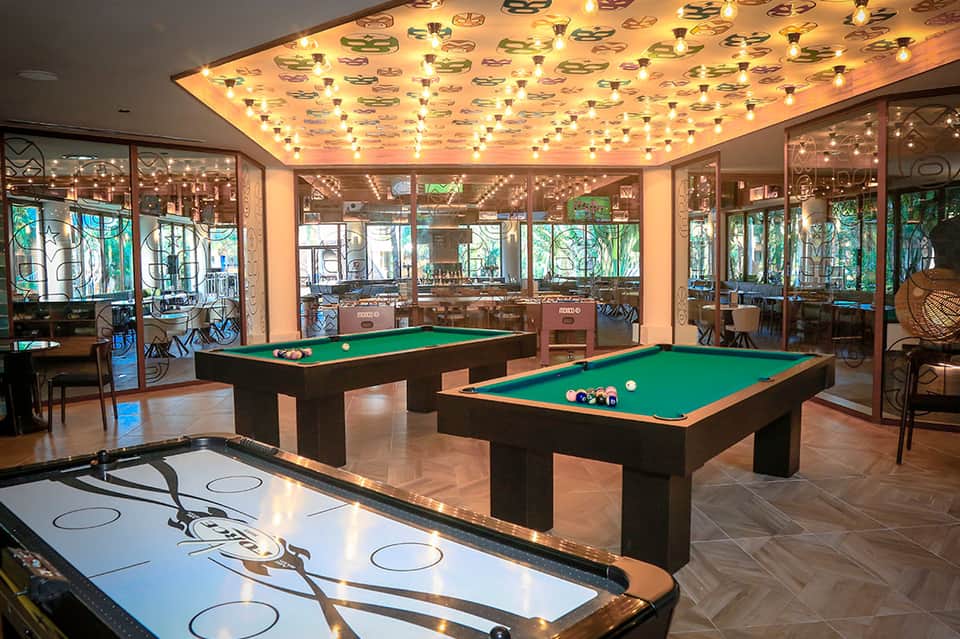 Recreation room with two pool tables, air hockey, and illuminated ceiling