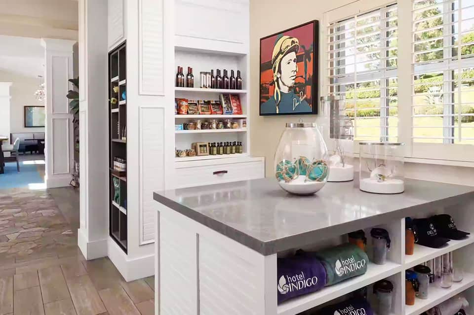 Modern hotel gift shop interior with white shelving, merchandise display, and pop art wall decor