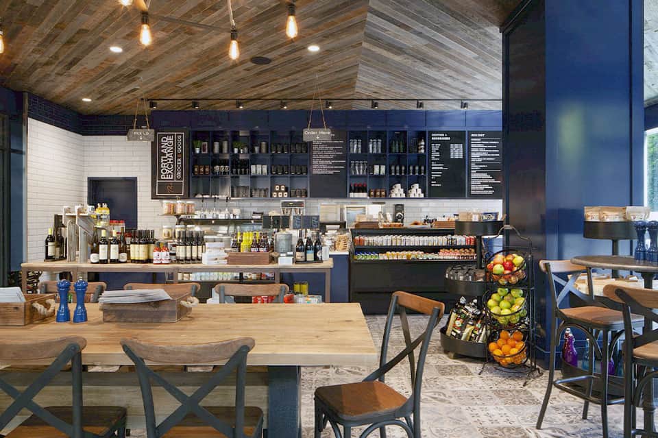 Modern cafe interior with wooden ceiling, subway tile walls, and espresso bar counter