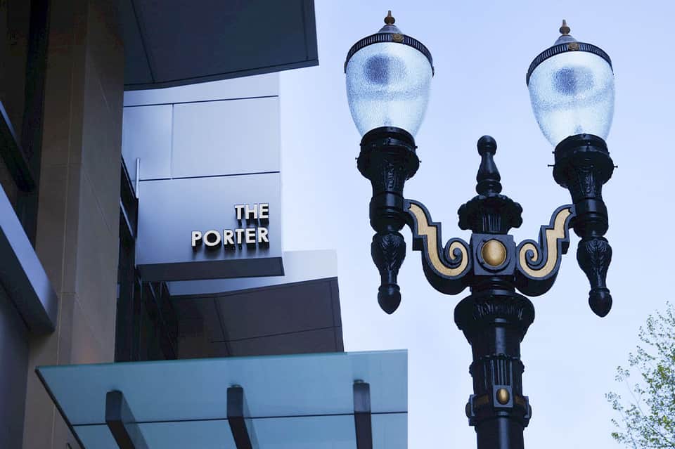 Street sign reading 'THE PORTER' with ornate black street lamp against blue sky