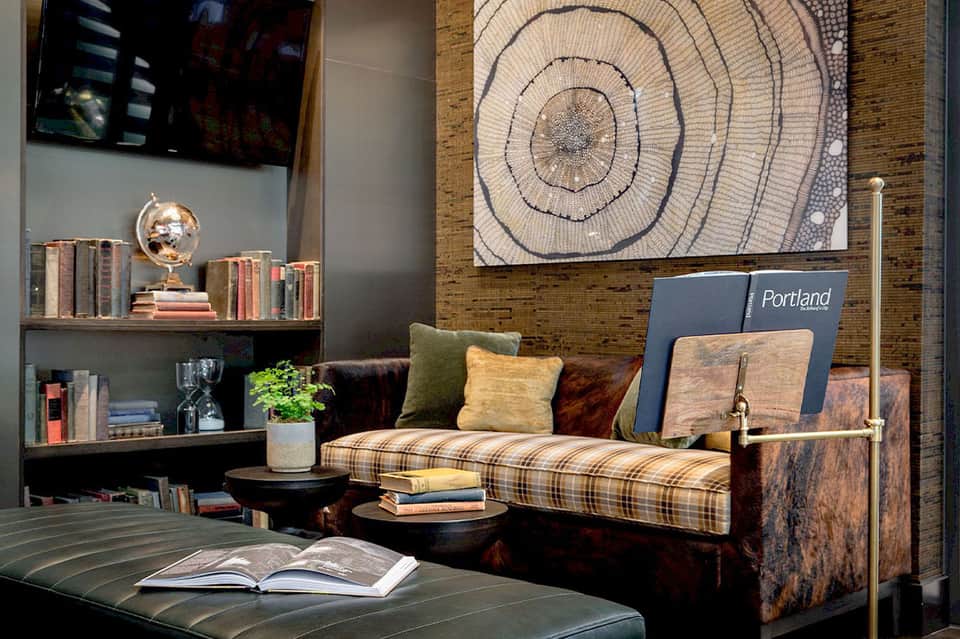 Contemporary hotel lobby lounge with plaid sofa, shelving, and geometric artwork