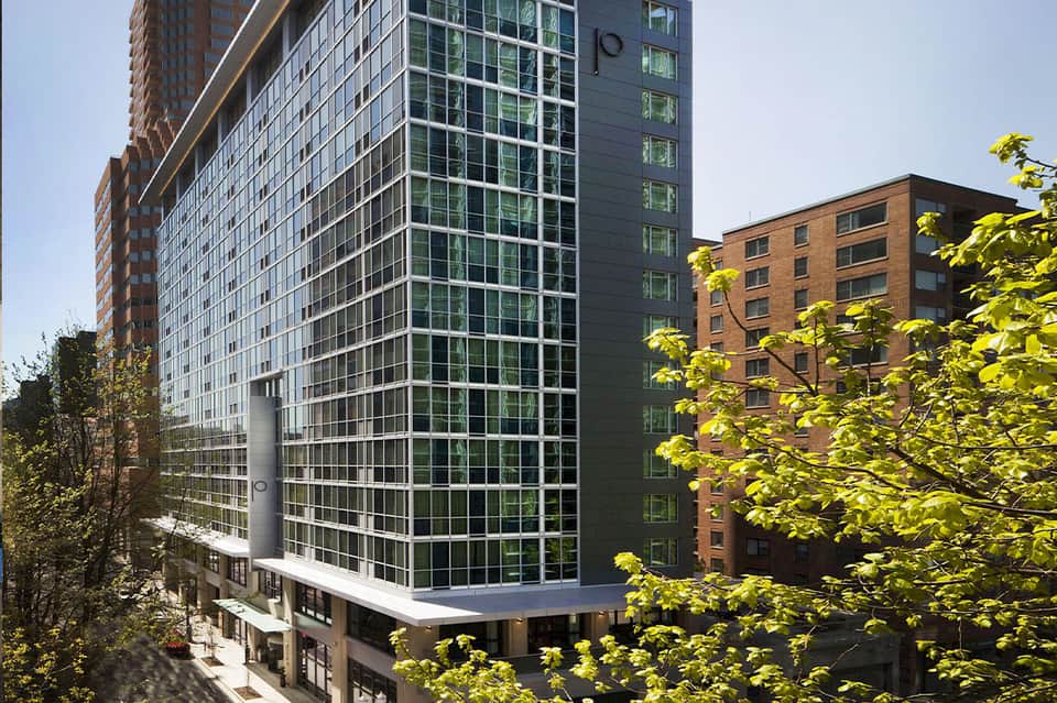 Modern high-rise hotel tower with glass windows and green vertical gardens