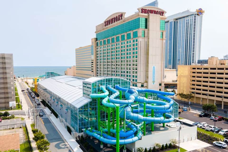 Beachfront water park with blue slide tubes and white covering adjacent to casino resort