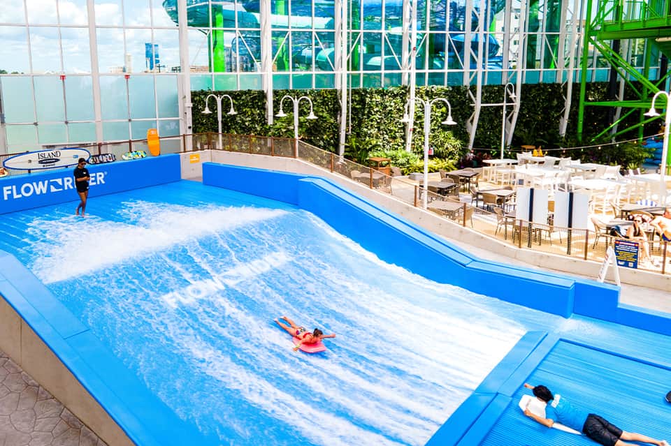 Indoor wave pool with artificial surfing feature and observation windows