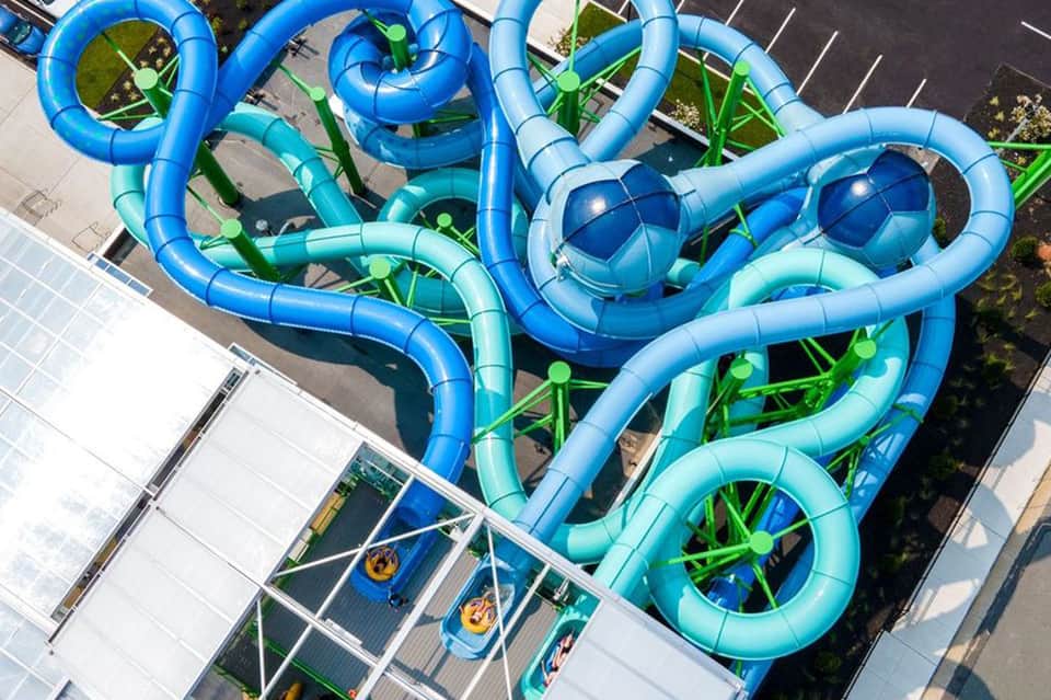 Aerial view of colorful blue water slides and splash park at resort recreation area