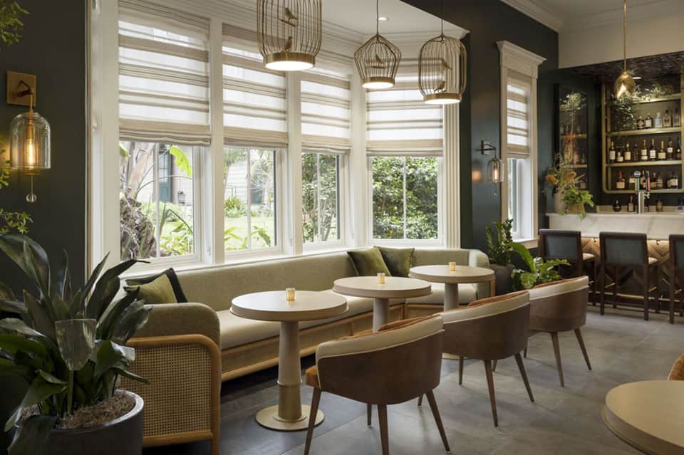Contemporary lounge with booth seating, large windows, and pendant lighting