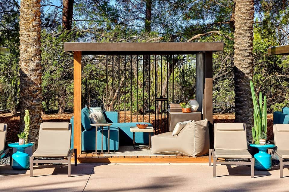 Resort relaxation pavilion with modern gazebo, lounge seating, and palm trees