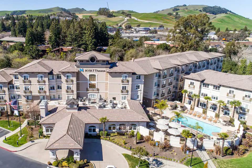 Hillside Hyatt House hotel exterior with multi-story buildings and resort pool amenities