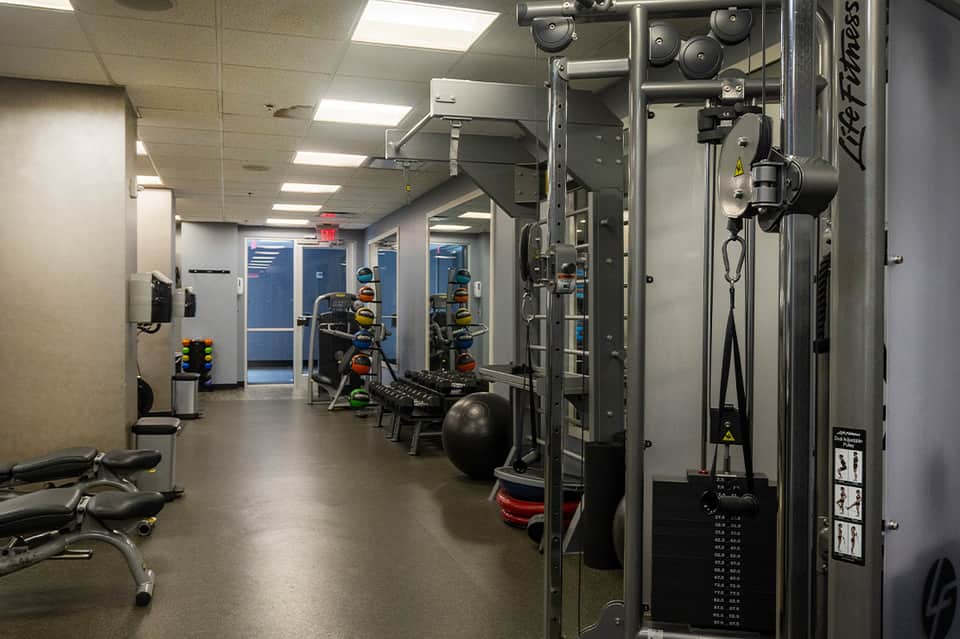 Modern hotel fitness center with weight machines, free weights, and exercise equipment