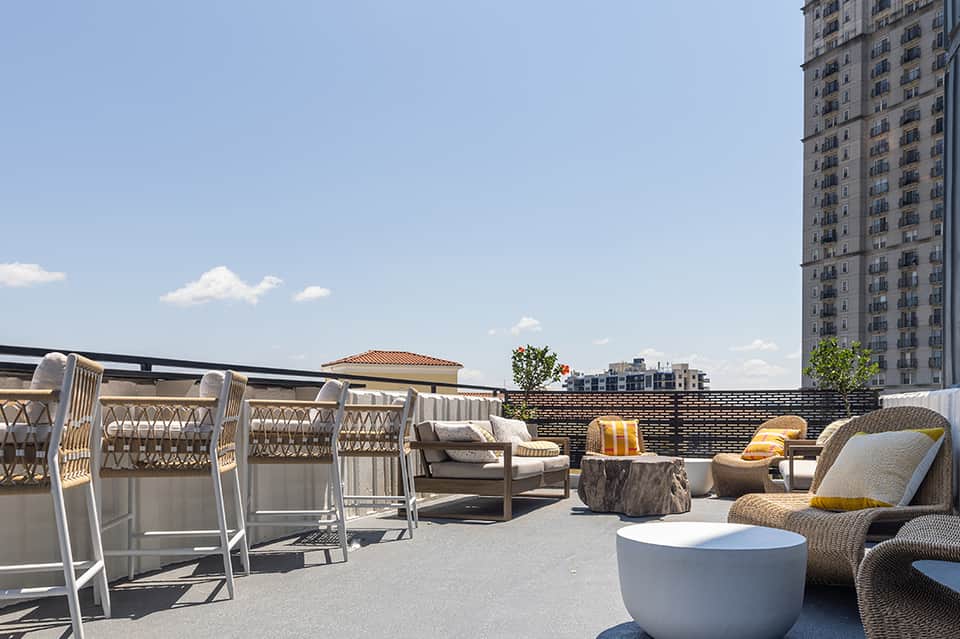 Rooftop terrace with modern furnishings, lounge seating, and cityscape views