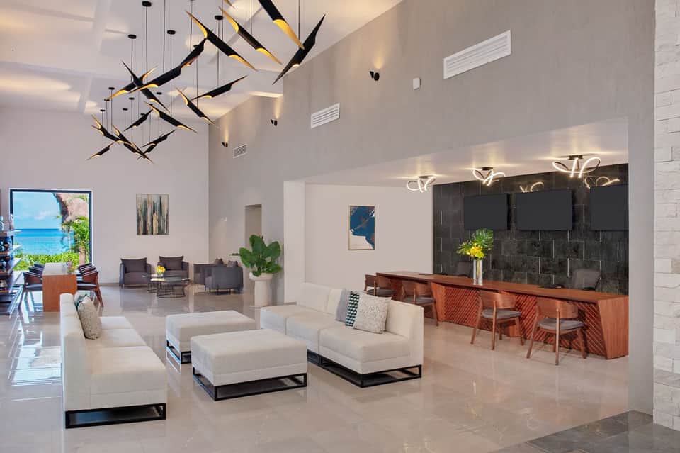 Modern hotel lobby with white marble, sculptural chandelier, and contemporary furnishings