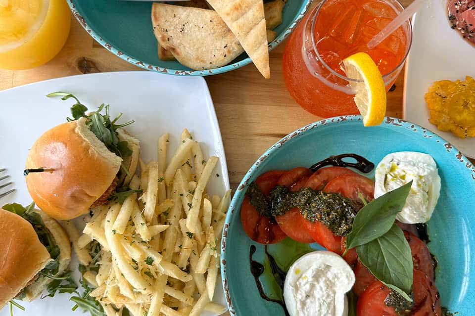 Resort dining overhead with fresh tacos, salads, cocktails, and colorful ceramic dishware