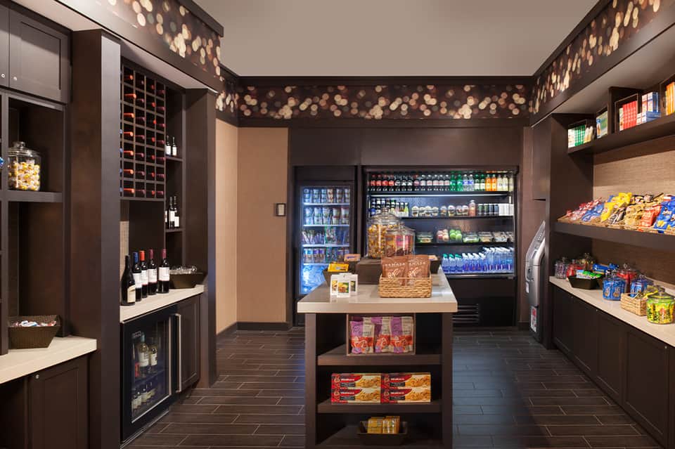 Modern convenience shop with wine display, beverage coolers, snacks, and decorative lighting