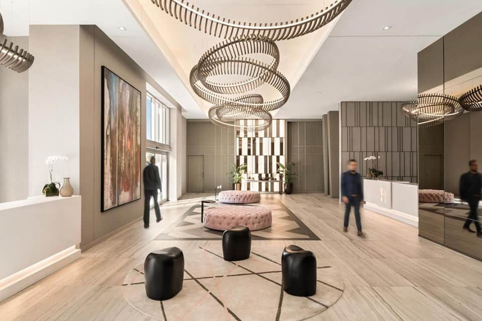 Luxury hotel lobby with circular pendant lights, polished flooring, and contemporary minimalist design
