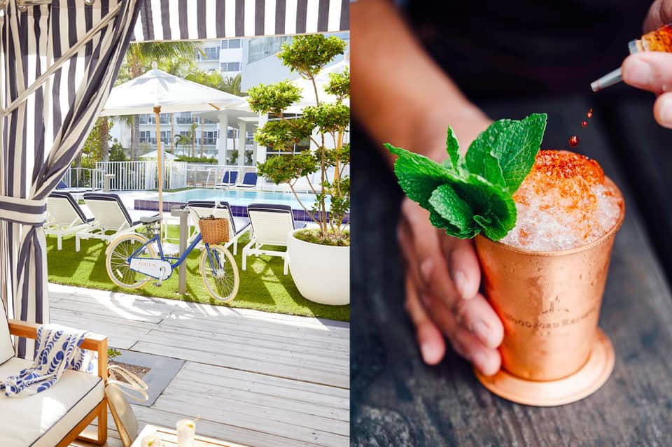 Beachside patio with striped umbrella, refreshing cocktail with mint garnish, bicycle, and pool view