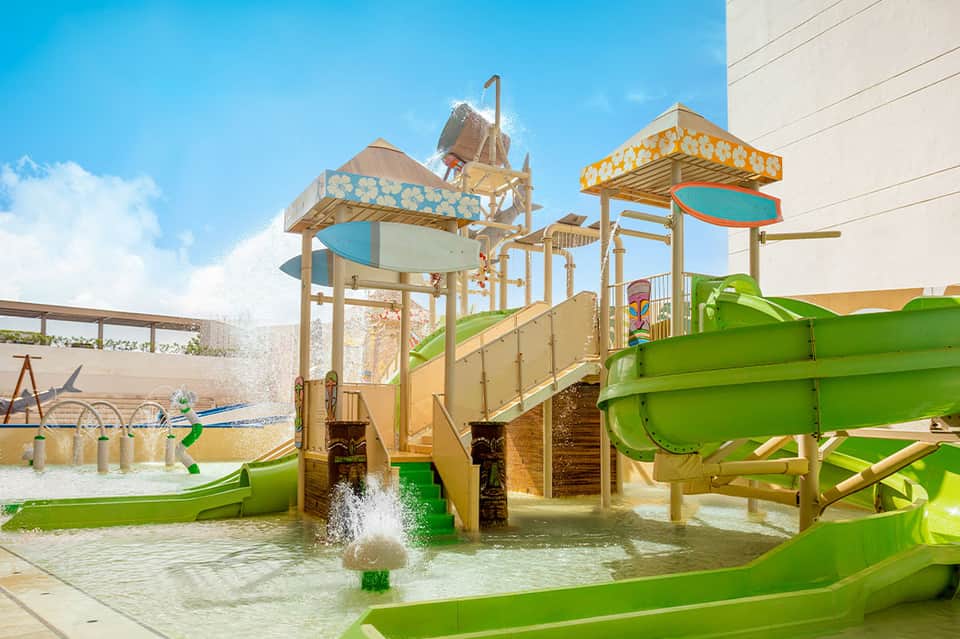 Colorful children's water park with green slides, splash features, and interactive water play