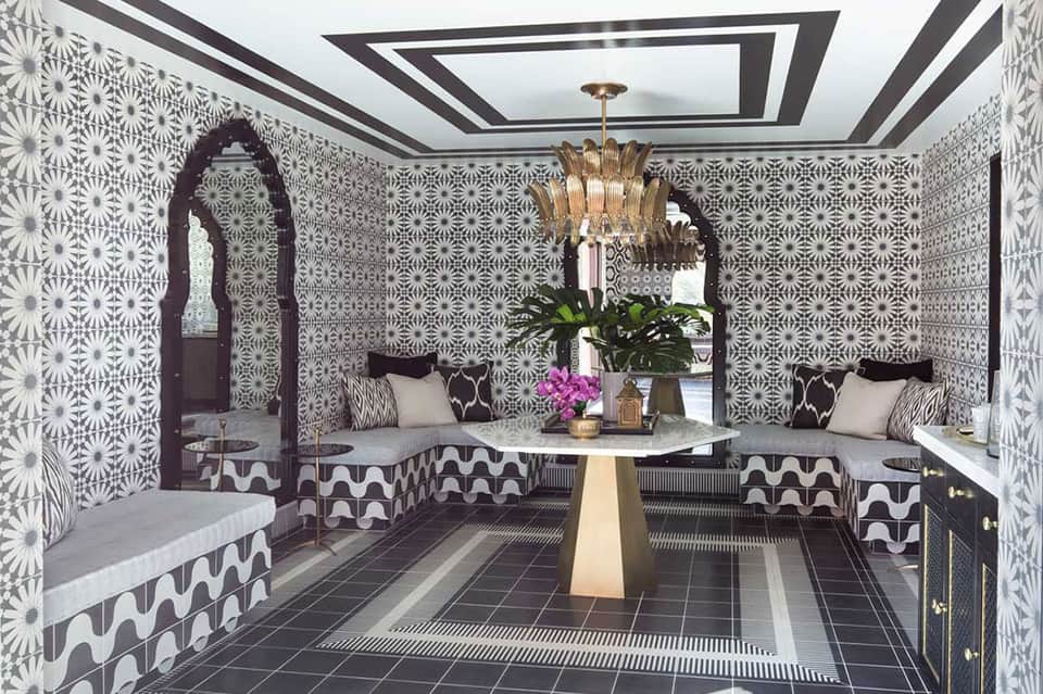 Ornate spa lounge with black and white geometric patterns, gold chandelier, and built-in seating
