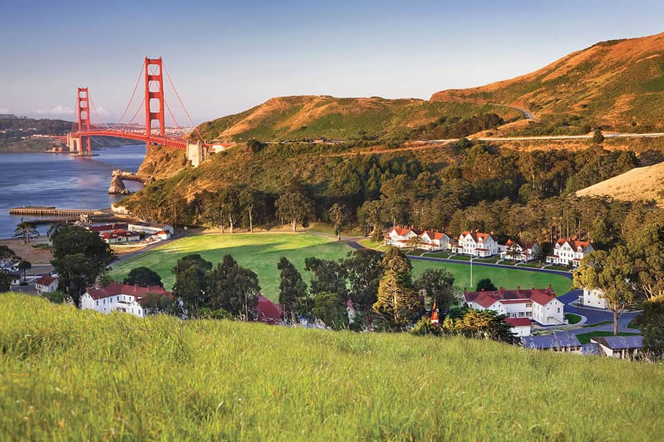 Golden Gate Bridge landscape with coastal homes and rolling green hills