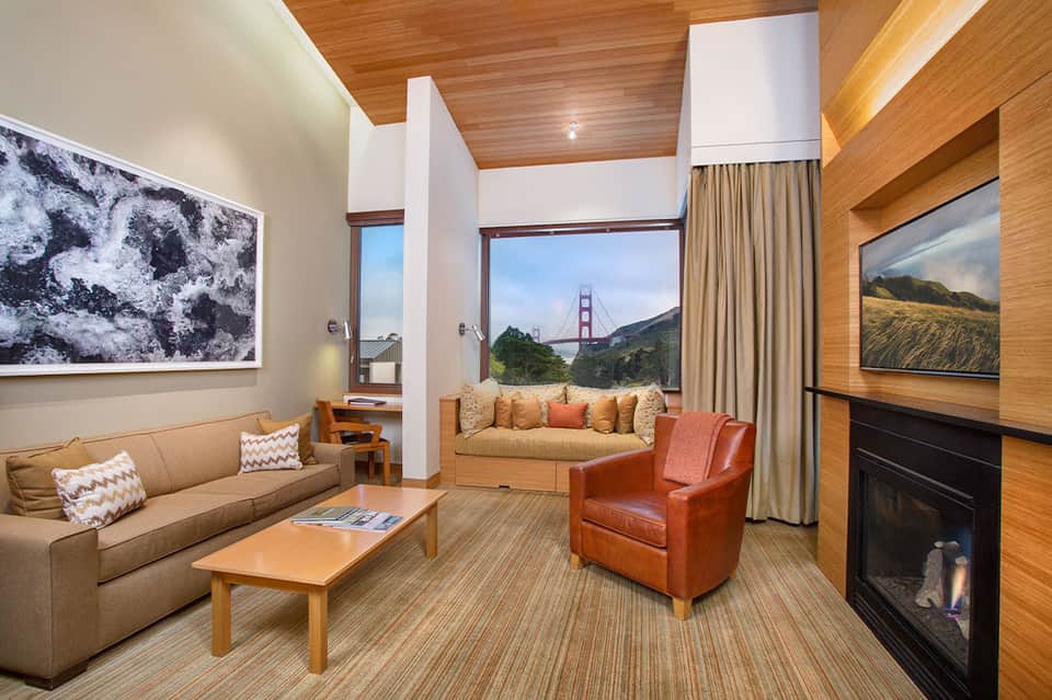 Upscale hotel suite with wood accents, fireplace, and floor-to-ceiling windows with bridge view