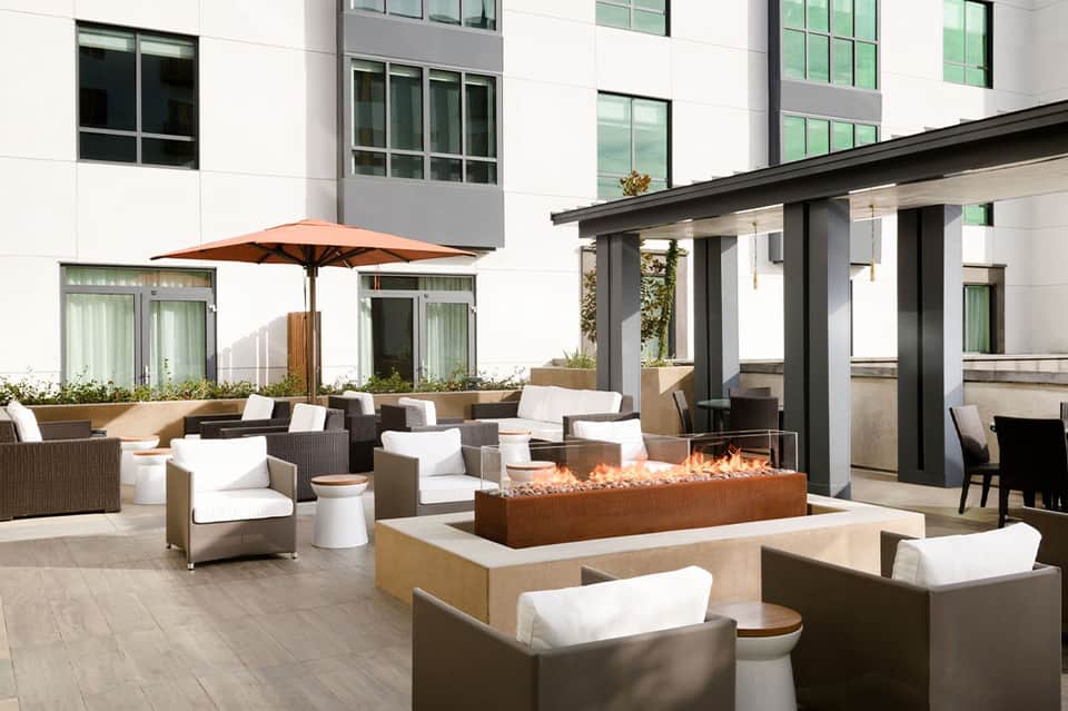 Modern patio with fireplace, comfortable seating, and contemporary architecture