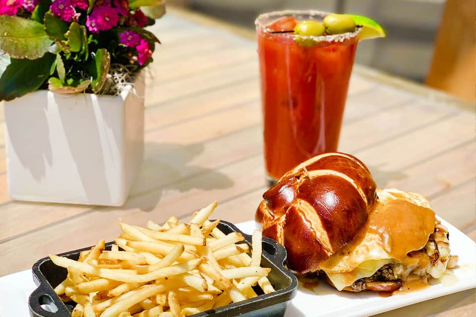 Gourmet burger with fries and tropical cocktail on an outdoor restaurant patio