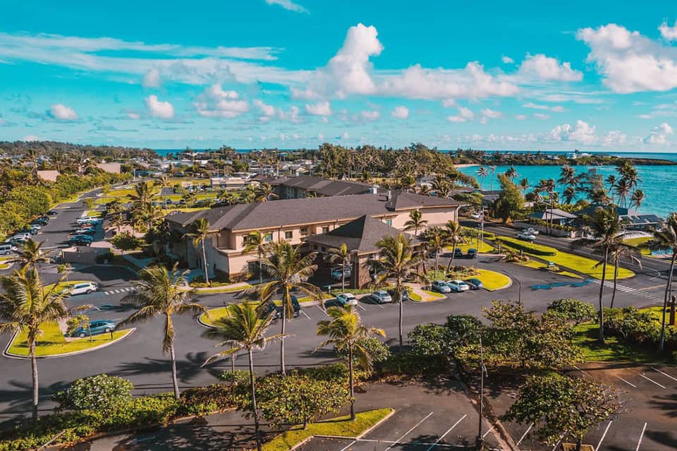 Aerial view of beachfront resort property with turquoise ocean waters and palm-lined grounds
