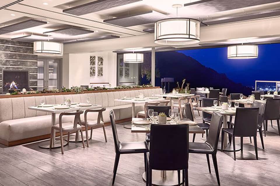 Modern upscale restaurant interior with blue evening views, banquette seating, and contemporary elegant design