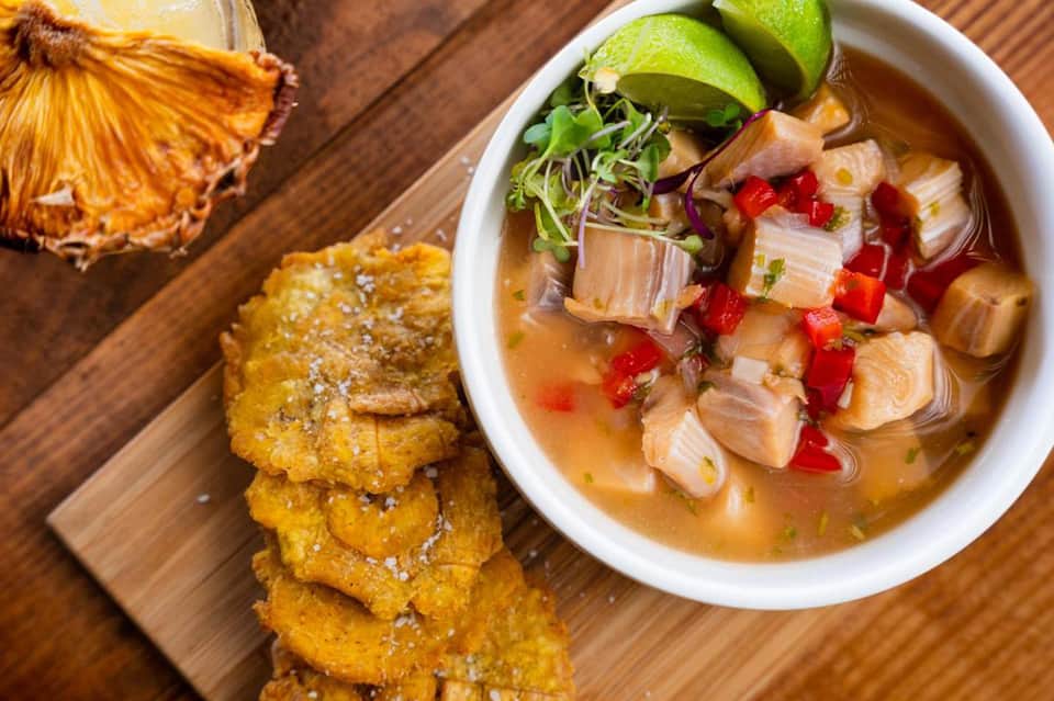 Ceviche seafood dish with fish, red peppers, lime, microgreens, and fried plantain chips