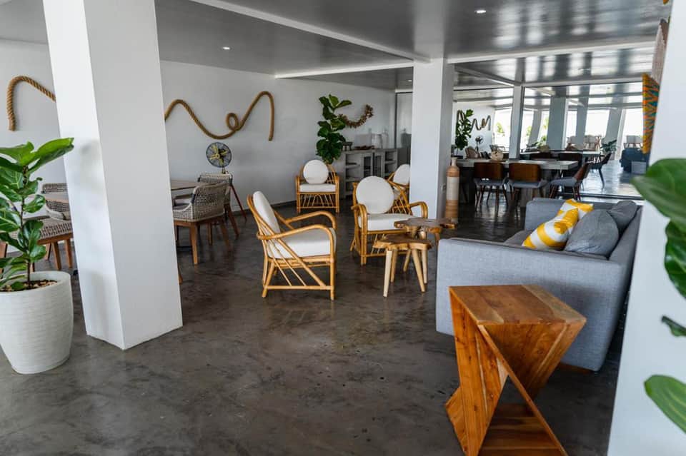 Modern resort lobby with rattan chairs, plants, and coastal decor